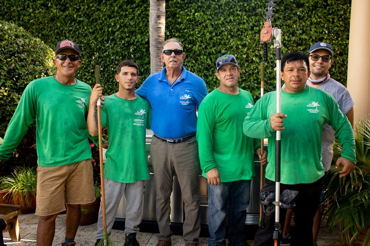 The Dan Ramos Landscaping crew in green and blue company shirts