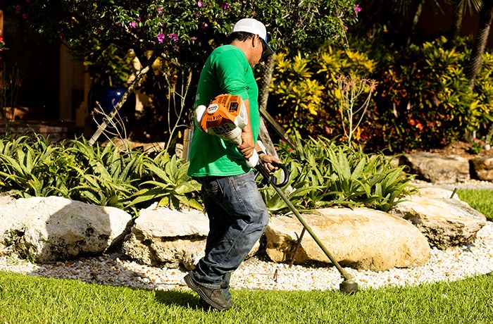 Dan Ramos crew member trimming a landscaped garden bed